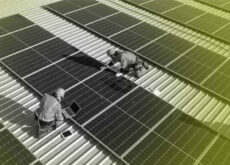 2 Männer arbeiten auf einem Dach.